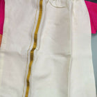 White pants with gold stripes on a pink surface