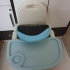 Children's chair with tray and seat cover on a tiled floor.